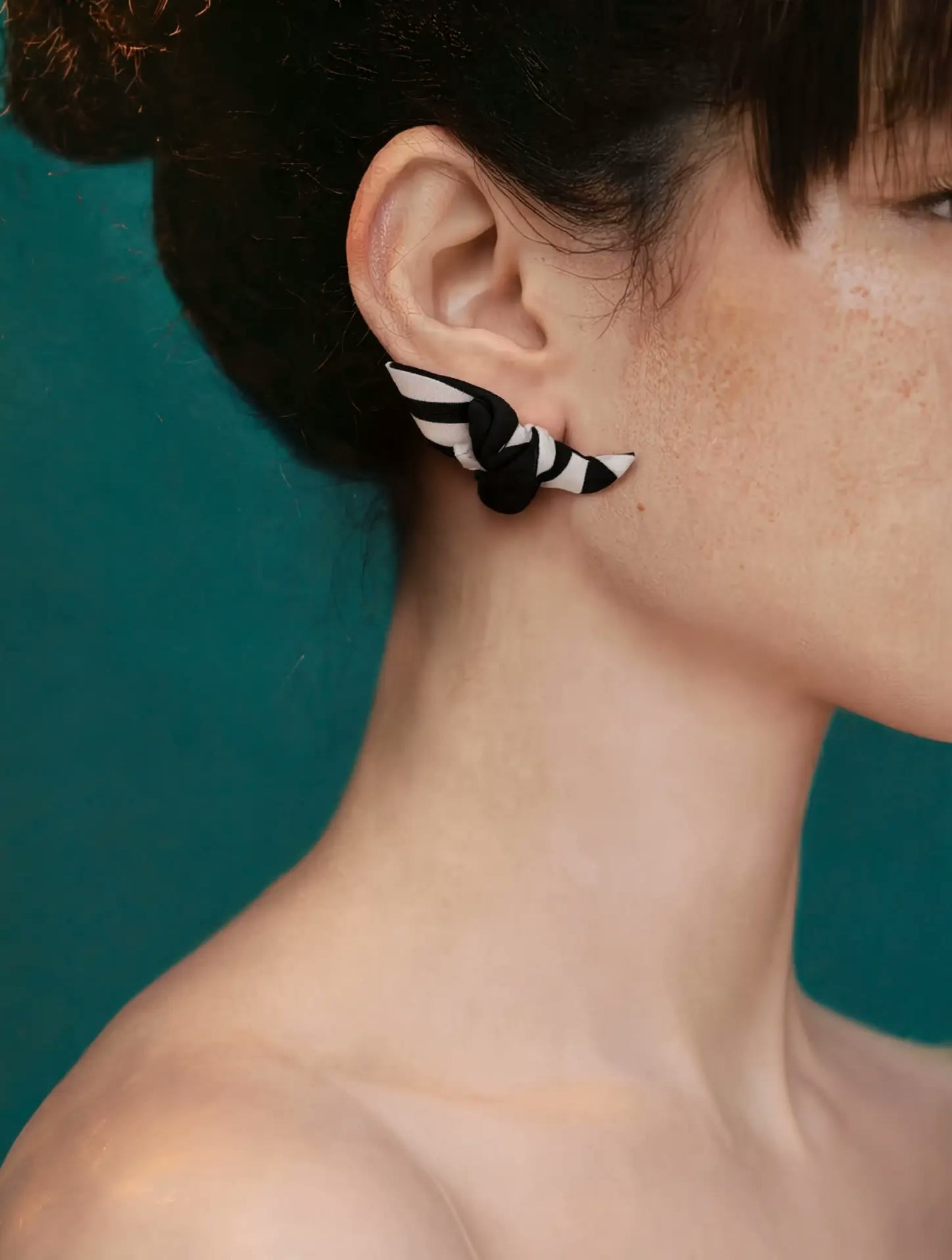 Profile view of Papillon silk knot earring